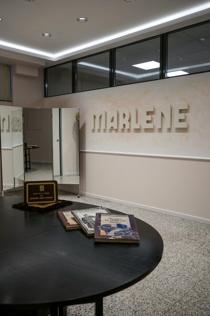 Lo showroom con la scritta Marlene alla parete e il tavolo rotondo nero